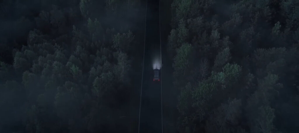 Dunkler Wald von oben mit einem einzelnen Licht