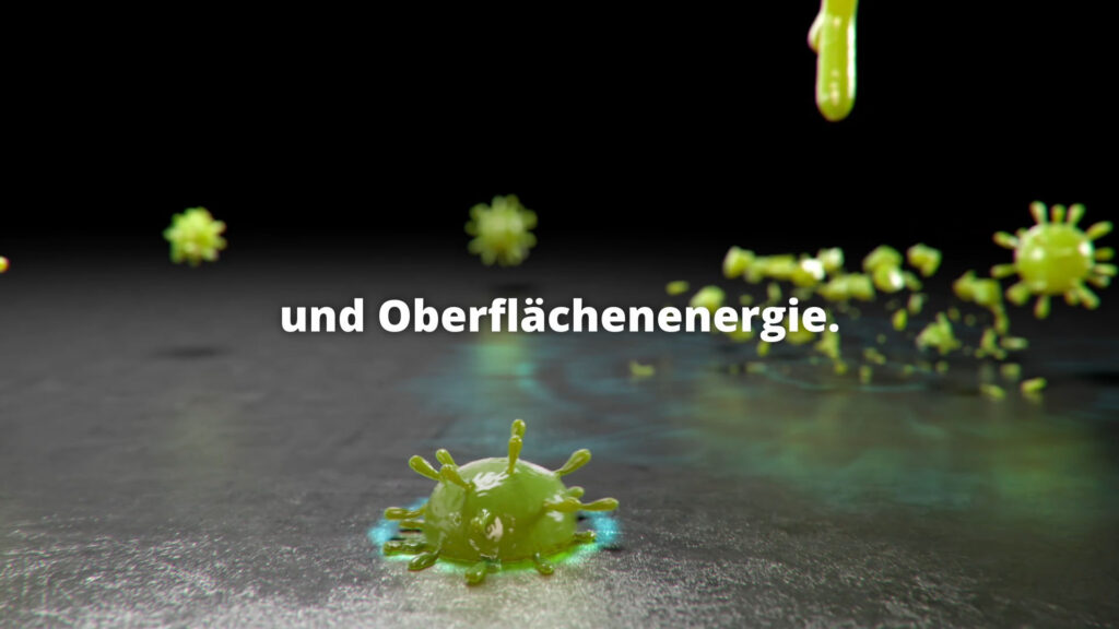 Grüne Mikroorganismen auf einer Oberfläche mit Texteinblendung zur Oberflächenenergie