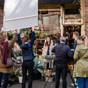 Videoproduktion Filmteam bei Dreharbeiten für eine Videoproduktion vor einem Blumengeschäft, mit Kamera auf Stativ, Beleuchtung und mehreren Personen im Einsatz