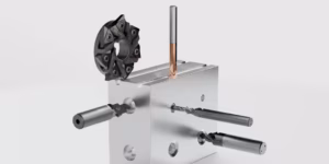 3D-Produktvisualisierung eines silbernen Metallblocks mit mehreren Bohrern und einem schwarzen Schneidwerkzeug auf der Oberseite.