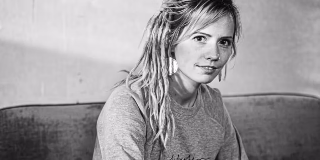 Frau mit Dreadlocks sitzt auf einem Sofa, Schwarzweißfoto